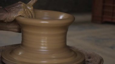 Mastering the Art of Pottery - A Close-up View of the Potter's Spinning Process