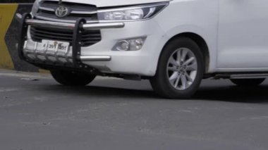 Bumper Scratch on White Car by Curb