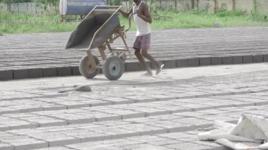 Man shoveling with large wheelbarrow - Construction site labor in progress
