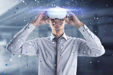 Happy young european businessman with abstract hologram and VR glasses in blurry office interior. Augmented reality and cyberspace concept clipart