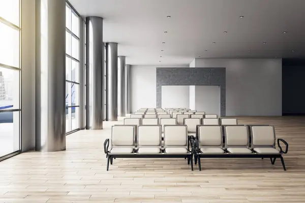 Front view on stylish airport seats in sunlit spacious empty waiting area hall in the airport with big panoramic windows and wooden floor. 3D rendering