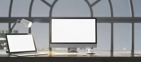 Close up of night designer workplace with empty white laptop computer screens, coffee cup and keyboard on wooden desktop and window with city view background. Mock up, 3D Rendering