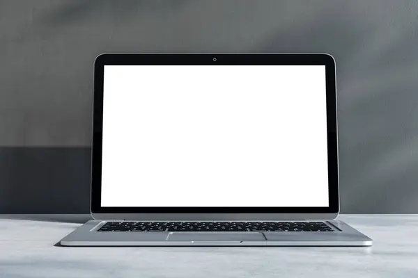 stock image Front view on blank white laptop monitor with place for your logo or text on light grey concrete surface and sunlit wall background. 3D rendering, mockup