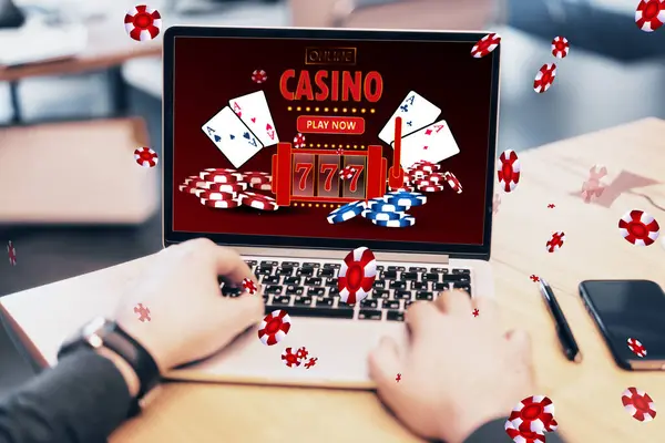 Online casino and gaming, gambling on device concept. Close up of male hands using laptop computer at workplace with creative slot machine and other games