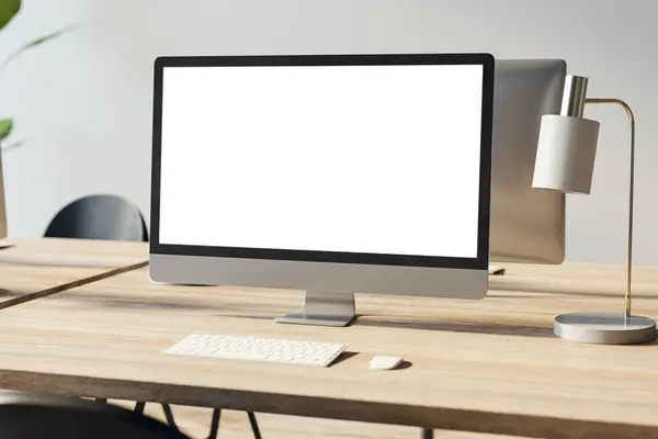 Close up of empty white computer screen on wooden office desktop with lamp and supplies on concrete wall background. Designer workplace concept. Mock up, 3D Rendering