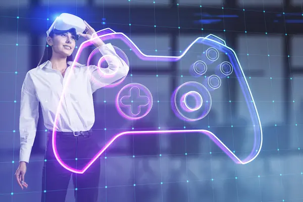 stock image Attractive young woman with VR glasses and creative joystick or gamepad hologram on blurry blue office background. Esport, gaming and fun concept. Double exposure