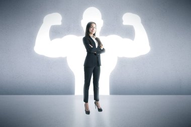 A businesswoman stands confidently with her arms crossed, casting a shadow of a muscular bodybuilder behind her clipart