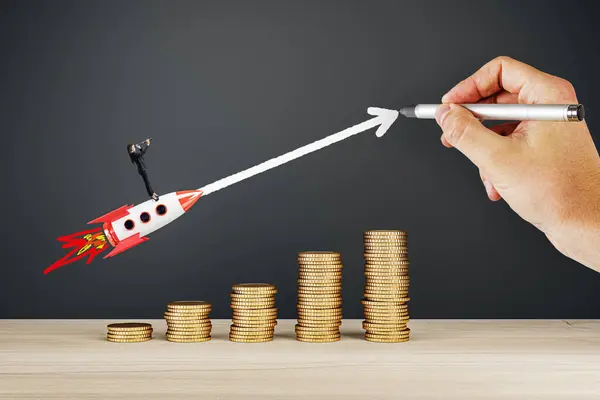 stock image A hand drawing a rocket symbolizing rapid business growth, launching from a stack of coins against a blackboard background