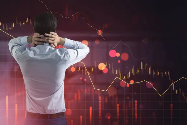 stock image A businessman viewing stock market graphs, illustrating a financial crisis concept on a digital background