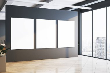 Büyük pencereli, şehir manzaralı ve parlak ışıklandırmalı bir şirket ofisindeki karanlık bir duvarda üç boş poster. İş yeri konsepti. 3B Hazırlama.