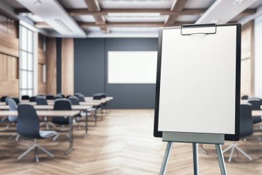 Çalışma seminerleri ve sunumlar için kullanılan ahşap döşeme ve siyah sandalyeli modern bir eğitim konferans salonunda boş tabela standı. 3B Hazırlama.