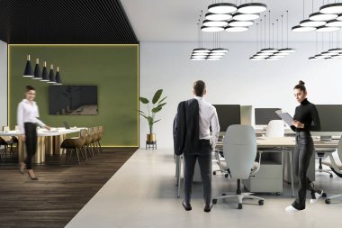 Zarif ışıklandırma, yeşil aksan duvarı ve takım çalışmasını ve üretkenliği gösteren açık çalışma alanı konsepti olan modern ofis içi iş adamları