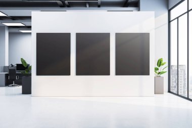 Modern ofis odasındaki beyaz bir duvara asılmış üç boş siyah poster çerçevesi. Büyük pencereleri, şehir arka planı ve temiz zemini var. 3B Hazırlama