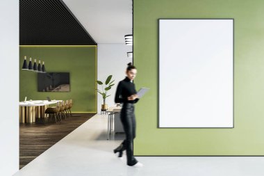 Ofis içi yeşil duvarlarla, duvarda boş dikey çerçeve, bulanık kadın yürüyüşü, modern tasarım konsepti, temiz iş ortamı