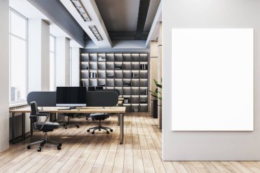 Masaları, bilgisayar monitörleri, kitaplıkları ve girişin yanındaki beyaz duvarda dikey boş tuval posterleri olan çağdaş ofis çalışma alanı. 3B Hazırlama