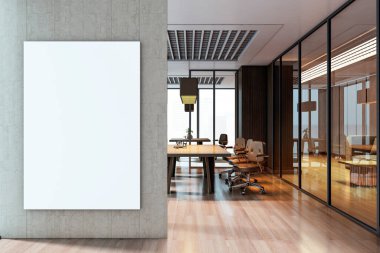 Ahşap masalı, cam bölmeli ve tavan lambalı modern ofis odasının yakınındaki beton duvarda dikey boş tuval poster modeli.