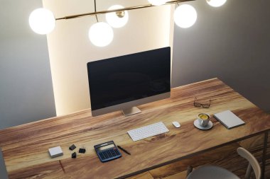 Ahşap masadaki boş bilgisayar ekranı ile modern çalışma alanı modellemesi temiz sunum tasarımı için arka plandaki ofis odasında. 3B Hazırlama