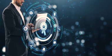 Profesyonel iş adamı dijital sertifika rozeti ve teknoloji ikonlarıyla dizüstü bilgisayarda çalışıyor. Karanlık arka plan kavramı üzerine fütürist ışık tasarımı.