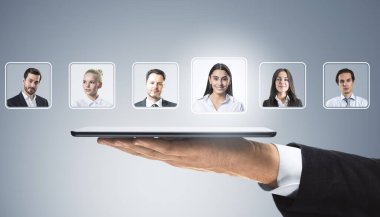 İş adamının elinde, üzerinde profesyonellerin yüzen portreleri olan tablet var. HR teknolojisini sembolize eden hafif bir gradyan arka planda yaratıcı bir kompozisyon.