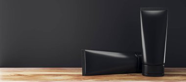 İki siyah kozmetik tüp, siyah bir masa üstüne yerleştirilmiş, arka planda karanlık bir duvar var, temiz ürün sunumu ve markalaşma modeli sergileniyor. 3B Hazırlama