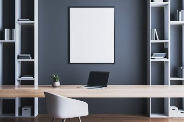 Modern ofis içi. Masanın üstünde boş poster modeli, dizüstü bilgisayar ve tahta masa üzerinde bitki, karanlık arka planda raflar. 3B Hazırlama