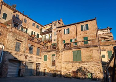 Siena, İtalya - 17 Aralık 2023: Yeşil panjurlu antik bina cephesi