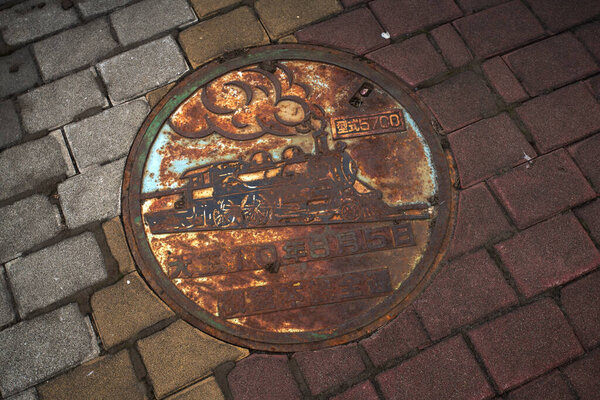Nemuro, Hokkaido, Japan - August 16, 2023 - Scene of manhole cover engraved with symbol and attractive of Nemuro