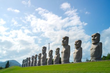 Sapporo, Ishikari Kaymakamlığı, Hokkaido, Japonya - 21 Ağustos 2023 - Makomanai Takino Mezarlığı 'ndaki giriş yolu boyunca uzanan Moai heykel başı