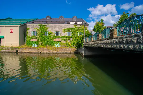 Otaru Kanalı, kanalın yanındaki eski depoların arka planına sahip güzel bir kanal ve diğer tarafta yürüme yolu, Otaru, Hokkaido, Japonya 'da ünlü bir yer.