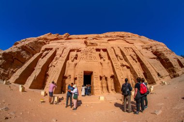 Aswan, Mısır - 23 Aralık 2022 - Ebu Simbel tapınaklarını ziyaret eden turistler, Küçük Hathor ve Nefertari Tapınağı 'nın girişinde