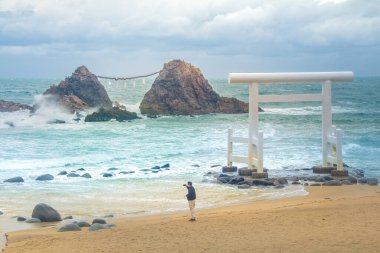 Itoshima şehrindeki Sakurai Futamigaura Sakurai Tapınağı 'nın beyaz Torii kapısı olarak bilinen Genkai Quasi-National Park' taki Meotoiwa, Fukuoka, Kyushu, Japonya adlı düğün çifti taşlarıyla ünlü.