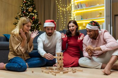 Yeni yıl partisi, evde oyun oynayan çeşitli arkadaşlar, Noel 'de birlikte gülümseyen ve mutlu kadınlar..