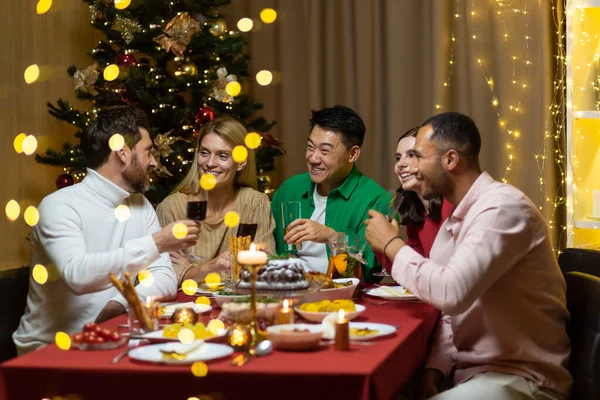 Arkadaşlar Noel arifesini ya da yılbaşı tatilini masada oturarak kutluyorlar. Memleketteki çok ırklı Noel ziyafeti. Neşeli insanlar kadehleri tokuşturur.