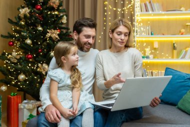 Olgun ebeveynler çocuklarına dizüstü bilgisayar kullanmayı internetten internet okumayı, oturma odasındaki koltukta oturmayı Noel ağacının arka planında oturmayı, anne ve babalarının küçük kızlarıyla birlikte oturmayı öğretirler..