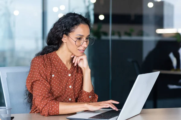 Modern ofis içinde çalışan başarılı Hintli kadın geliştirici programcı, programlama kodu yazmak için bilgisayarını kullanıyor, gülümsüyor ve mutlu başlangıç yapıyor..