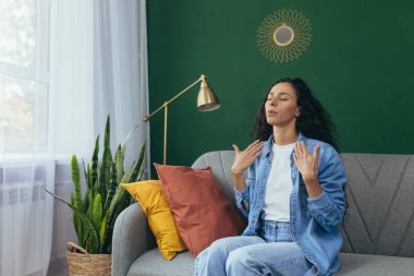 Panik atak geçiren kadın evde yalnız başına. Korkmuş İspanyol kadın. Oturma odasında kanepede otururken nefes almakta zorlanıyor..