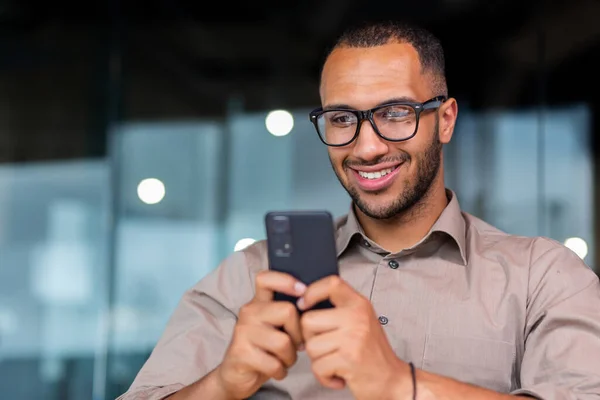 Zbliżenie Uśmiechniętego Afro Amerykańskiego Biznesmena Korzystającego Wiadomości Telefonicznych Przeglądającego Strony — Zdjęcie stockowe