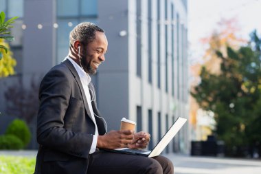 İşte kahve molası. Afro-Amerikalı bir ofis çalışanı, dışarıda bankta kulaklık takarak oturuyor. Elinde bir fincan kahve ve dizüstü bilgisayar var. Görüntülü konuşuyor, gülümsüyor, dinleniyor..