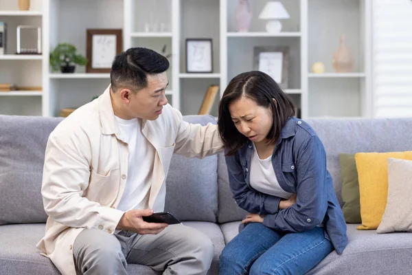 Young Asian Man Comforts Supports Woman Sitting Sofa Home Holding — Stock Photo, Image