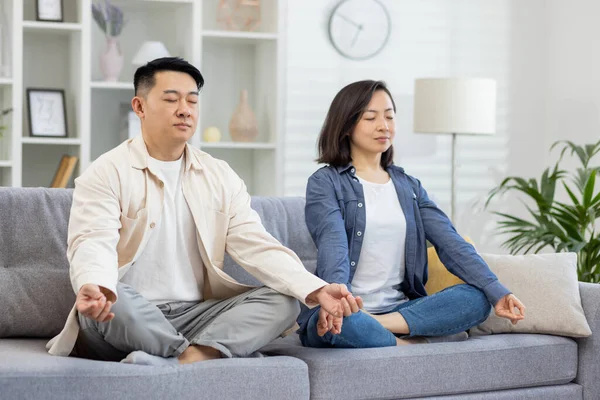 Evdeki Mutlu Asyalı Aile Kanepede Meditasyon Yapıyor Çift Erkek Kadın — Stok fotoğraf