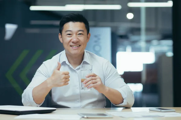 Ung Asiatisk Man Sitter Vid Ett Skrivbord Kontoret Och Håller — Stockfoto