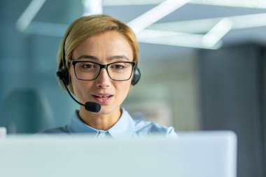 Genç bayan ofis çalışanı, kulaklıklı video görüşmesi için iş kadını müşteriyle uzaktan konuşma, müşteri desteği teknoloji işçisi konuşması ve danışmanlık, iş yerinde başarılı kadın.
