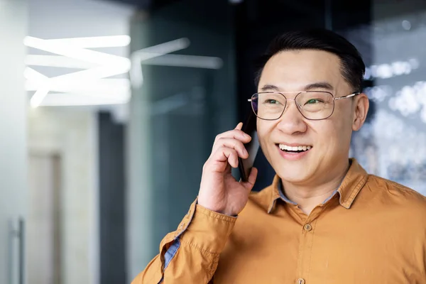 Framgångsrik Och Glad Asiatisk Affärsman Talar Telefon Med Kunder Inne — Stockfoto
