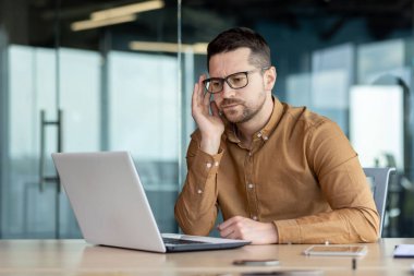 Düşünceli ve ciddi bir erkek öğrenci kampüs kütüphanesinde bir masada oturuyor ve bir dizüstü bilgisayarla ders çalışıyor. Sınava giriyor, sınav yazıyor, mülakatı geçiyor, video dersi dinliyor..