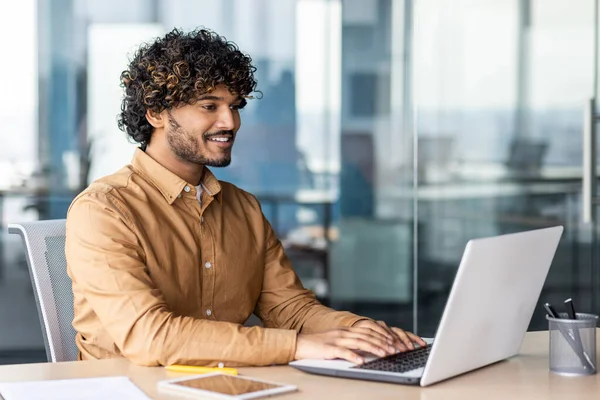 stock image Portrait of young successful contemporary businessman inside office, man at workplace smiling, young hispanic businessman sitting at desk using laptop