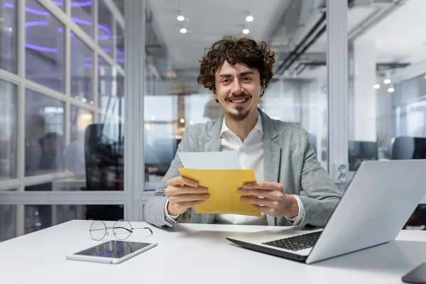 Portrait of happy mature investor businessman in office, man looking at camera and shocked happy and smiling, boss opening envelope with good news notification