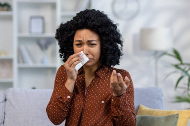 Üzgün genç Afrikalı Amerikalı kadın ağlıyor, acı çekiyor, sorunları var, kamera karşısında konuşuyor, psikolojik yardıma ve desteğe ihtiyacı var. Gözyaşlarını peçeteyle siler.