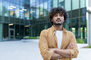 Kendine güvenen ve başarılı genç bir profosyonel programcının portresi, ofis merkezinin önünde duran İspanyol bir adam, kollarını göğsünün üzerine koyup kameraya bakıyor..