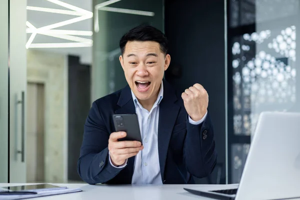 Feliz Joven Asiático Trabajando Oficina Sentado Mesa Usando Teléfono Mirando —  Fotos de Stock