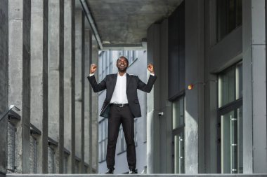 Başarılı Afro-Amerikan iş adamının portresi zaferi kutlayan ve ofis çanlarını çalan başarılı adam başarı elde eden çalışanlardan memnun..